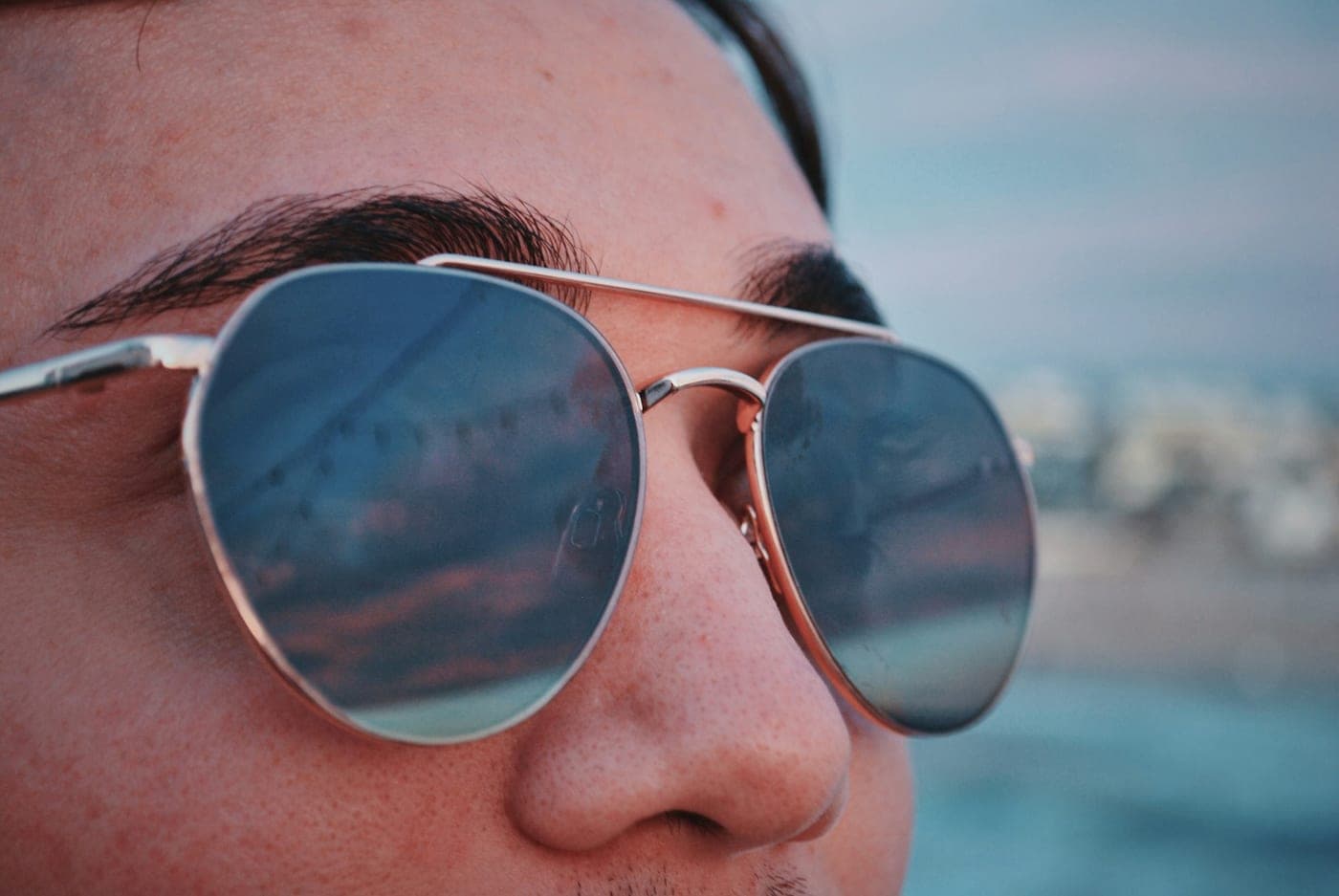 Close portrait in thin metal aviator sunglasses with a double bridge