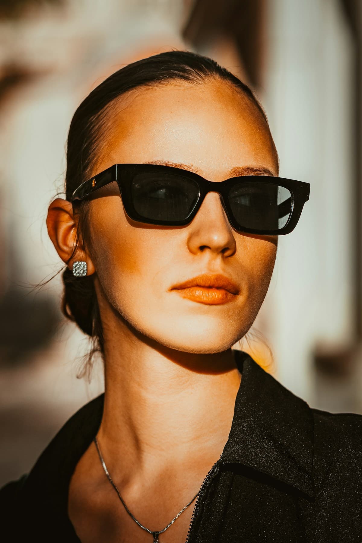Portrait in heavy rectangular black acetate sunglasses